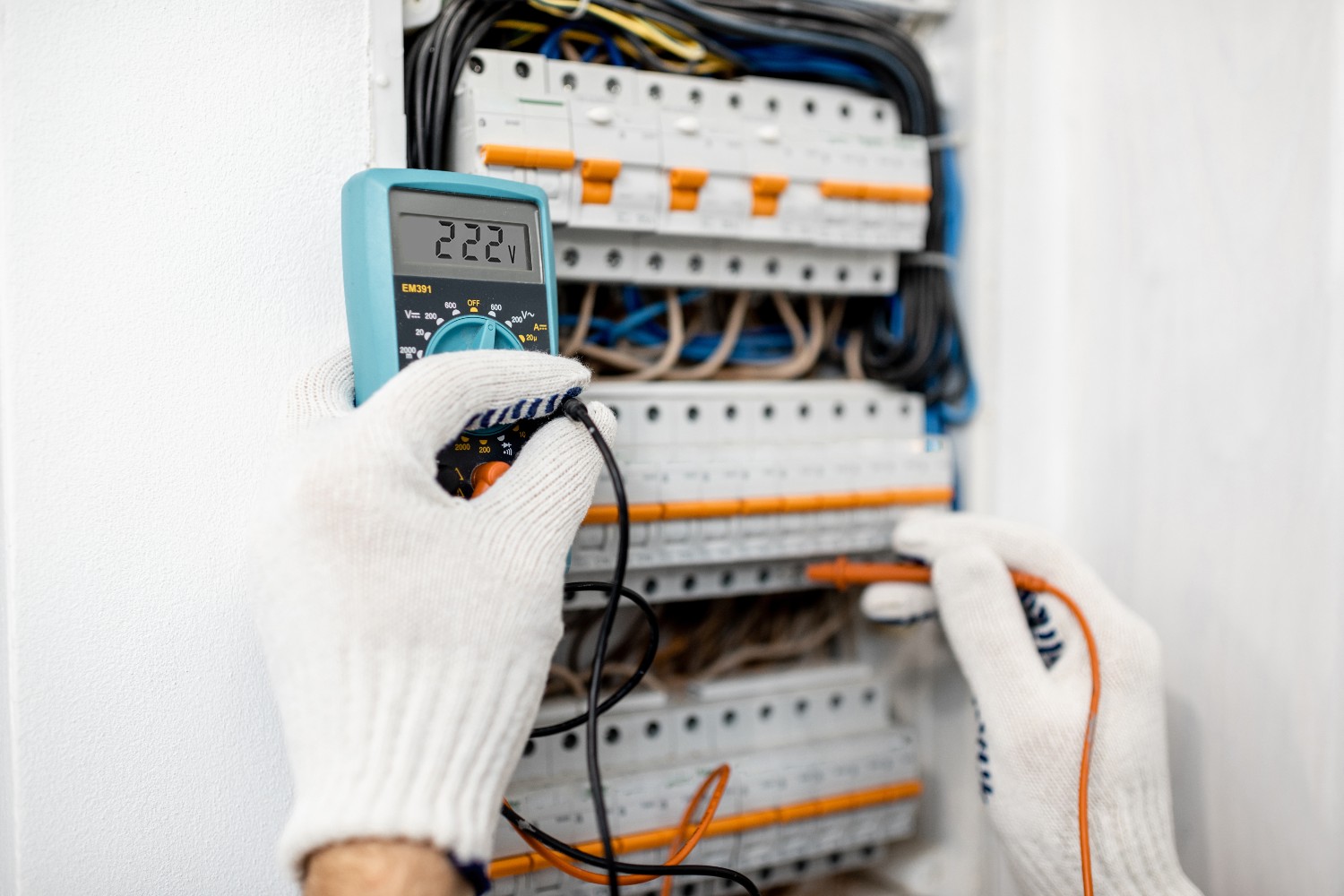 Electrician installing or repairing apartment electrical panel, close-up view